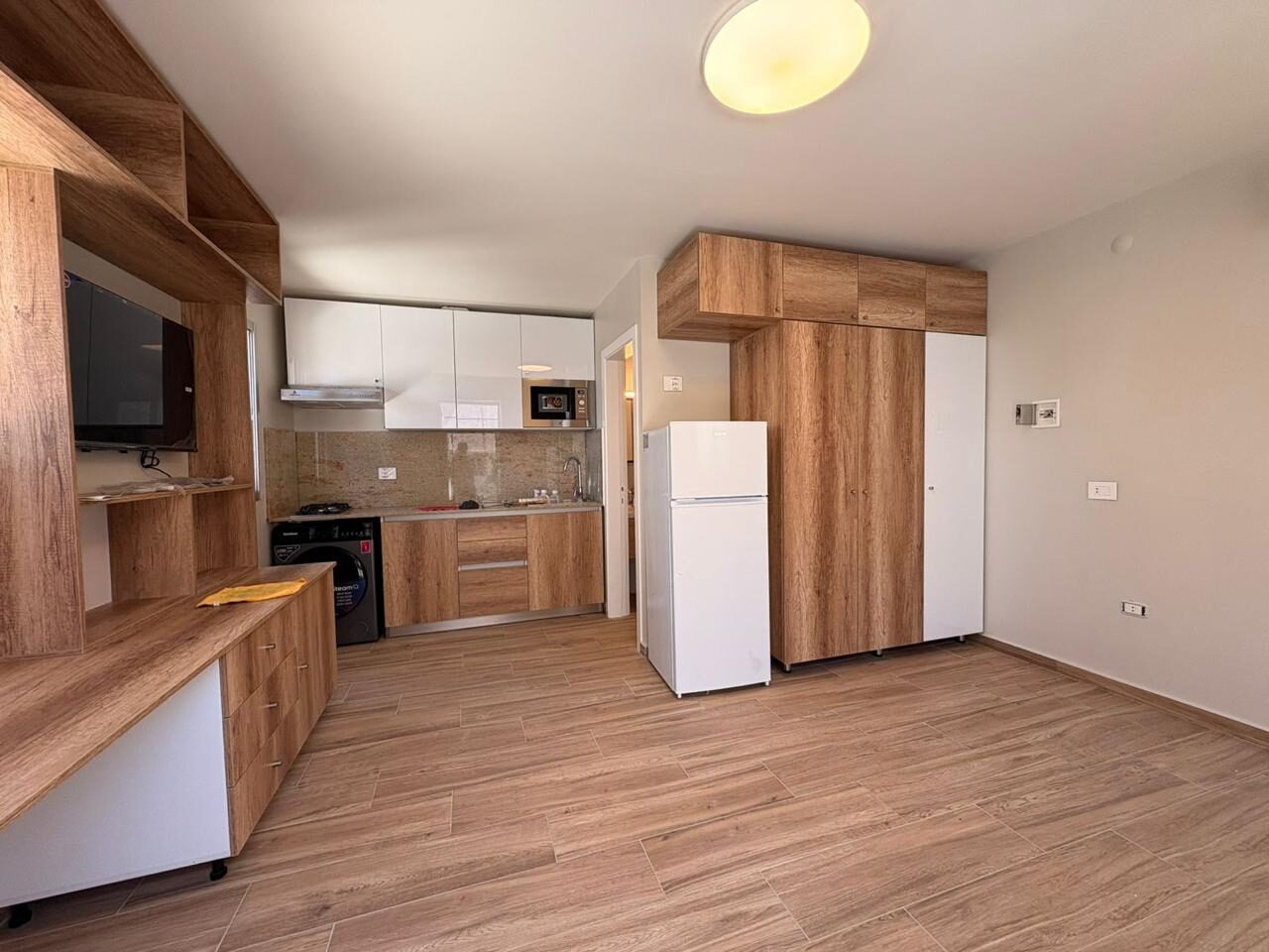 Studio living wall with built-in TV unit and kitchen