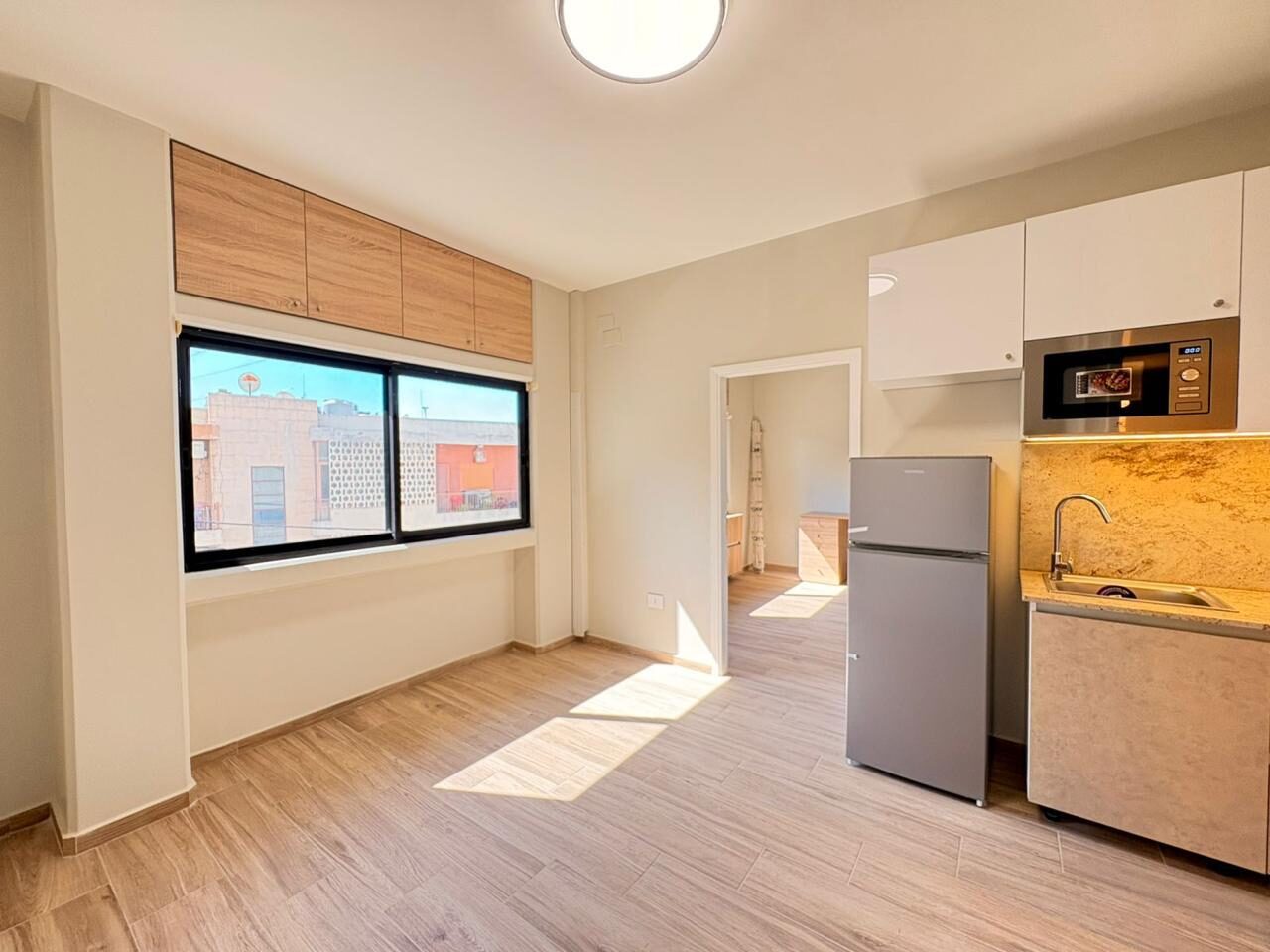 Bright studio room with kitchenette and window