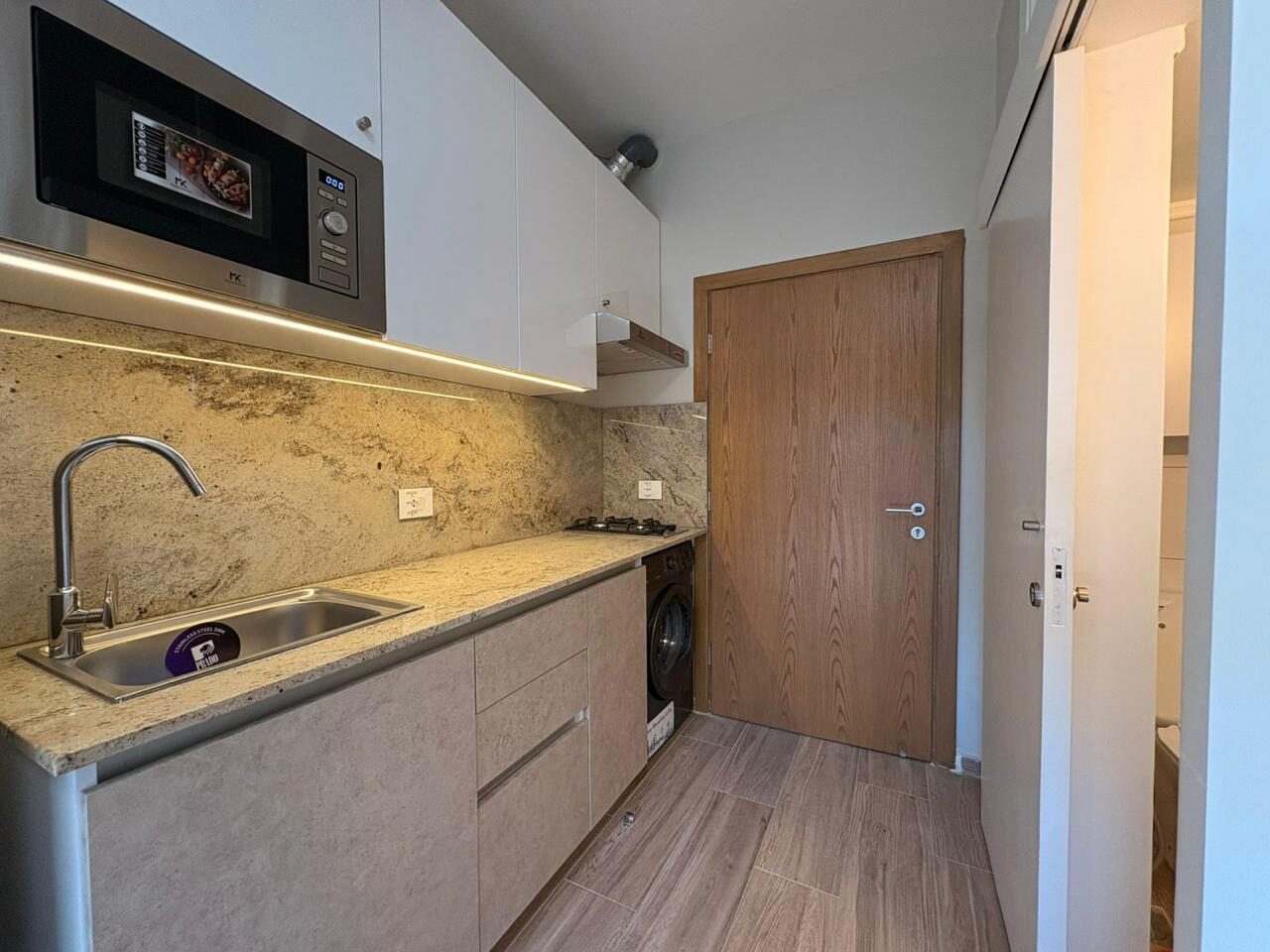 Stone kitchen counter under warm cabinet lighting